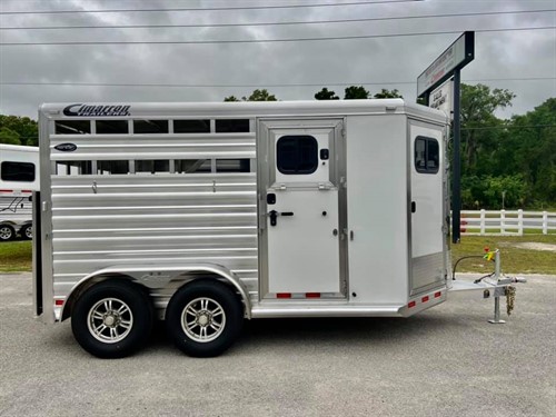(On Order) 2022 Cimarron (2) horse straight load bumper pull trailer with a front tack room that has saddle racks, bridle hooks, carpet lined wall, windows in nose, brush box and an interior light. The horse area has an interior height at 7’1” tall x 7’ wide, (2) escape doors, insulated roof, roof vents, rubber lined & insulated walls, removable divider, rubber mats over all aluminum floor,