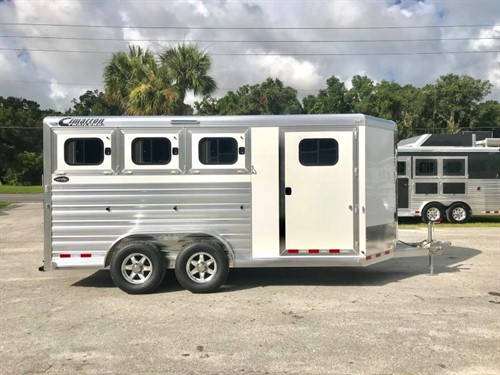 (On Order) 2021 Cimarron (3) horse slant load bumper pull trailer with the “Ready to Go Package” that contains a swing out saddle rack, bridle hooks, clothe rod, door caddy, swing out pad rack, water tank and a walk thru door. The horse compartment has an interior height at 7’ 2” tall x 7’ wide, escape door with a drop down window, drop down windows at the horses heads and hips, insulated roof, roof vents, rubber lined & insulated walls,