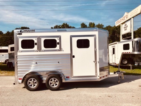 (On Order) 2022 Cimarron (2) horse slant load bumper pull trailer with a front tack room that has saddle racks, bridle hooks and a brush box.  The horse area has an interior height at 7'6" tall x 7' wide, drop down windows at the horses heads with drop down aluminum bars, drop down windows at the horses hips, insulated roof, roof vents, rubber lined & insulated walls, rubber mats over all aluminum floor and double back rear doors!  The exterior has aluminum wheels and a spare tire.  